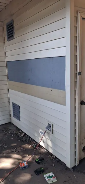 A replaced section of siding is still unfinished on this wall.