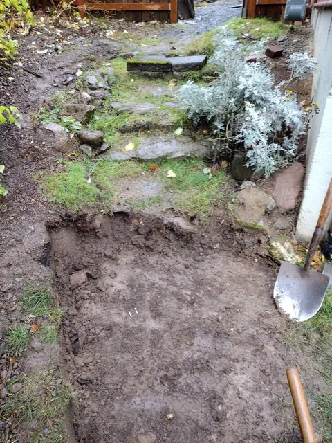 The old, uneven stone path with the first section dug out ready for the new steps.
